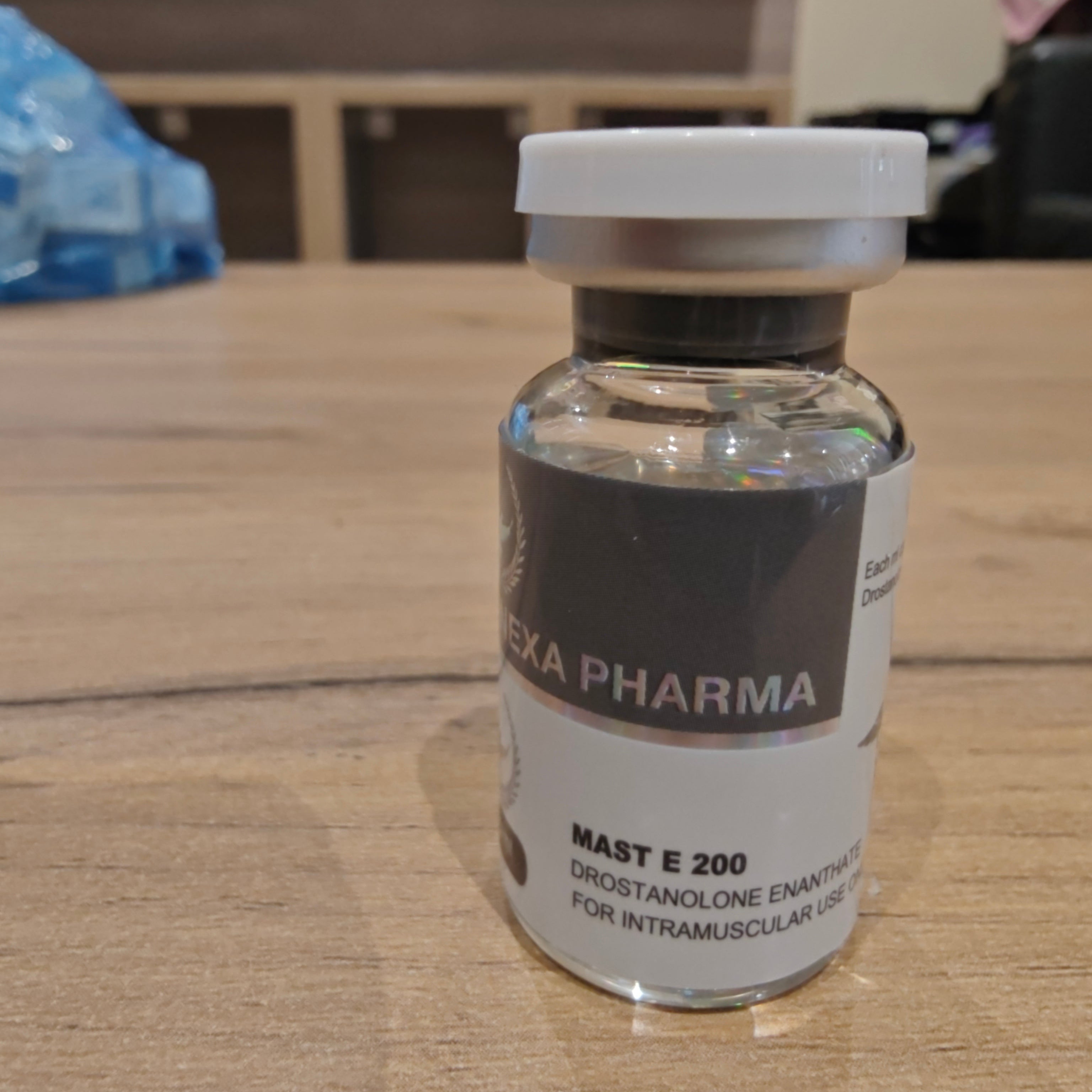 Vial labeled 'Hexa Pharma' on a wooden surface